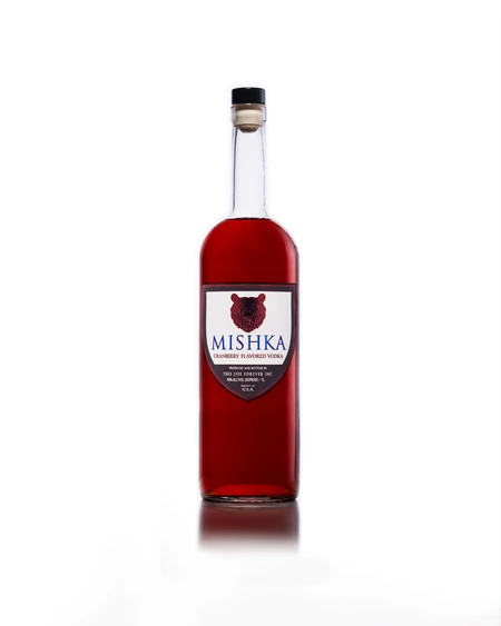 The Mishka Cranberry bottle, deep red spirit behind a white shield label with a red bear.