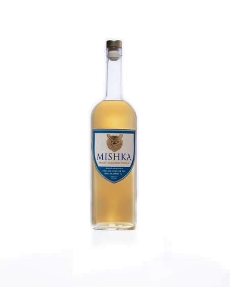 The Mishka Honey bottle, golden spirit behind a blue shield label with a gold bear.