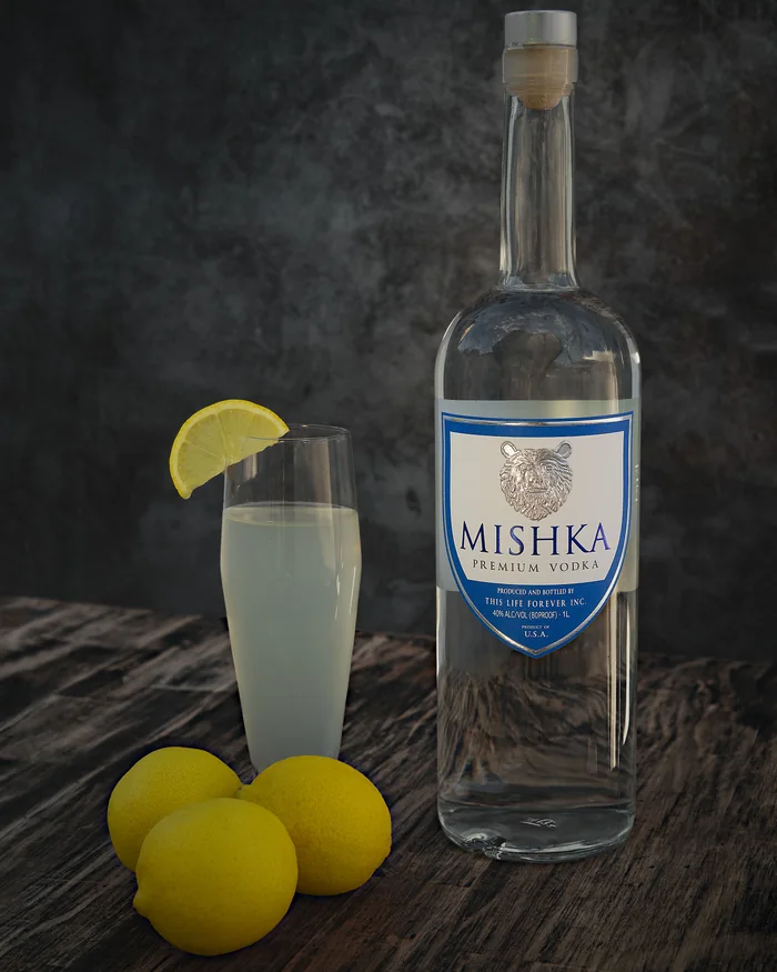 A full Mishka Premium Vodka bottle beside a tall lemon cocktail and three lemons.